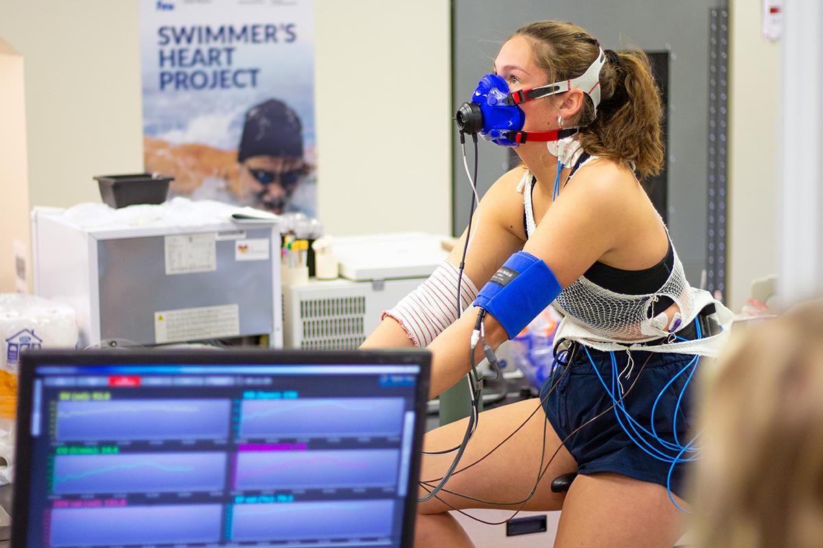 Patient riding a bicycle with electro sensors attached to her body