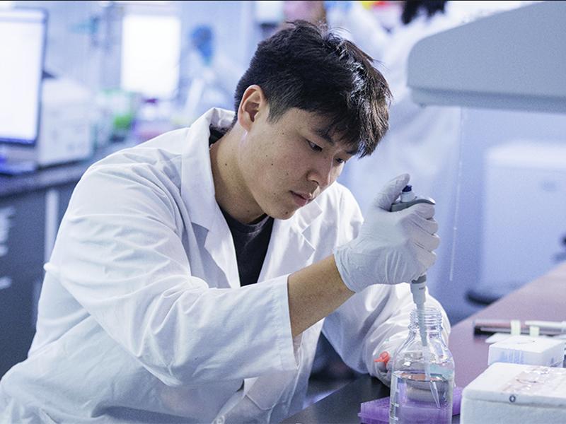 U of G researcher in lab with pipette