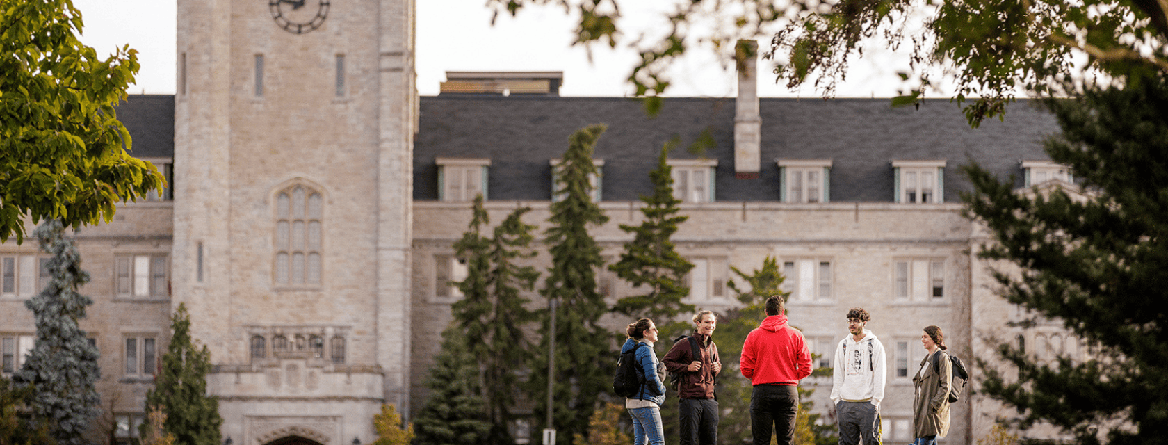 U of G's campus shot featuring Johnston Hall and some students besides the trees.
