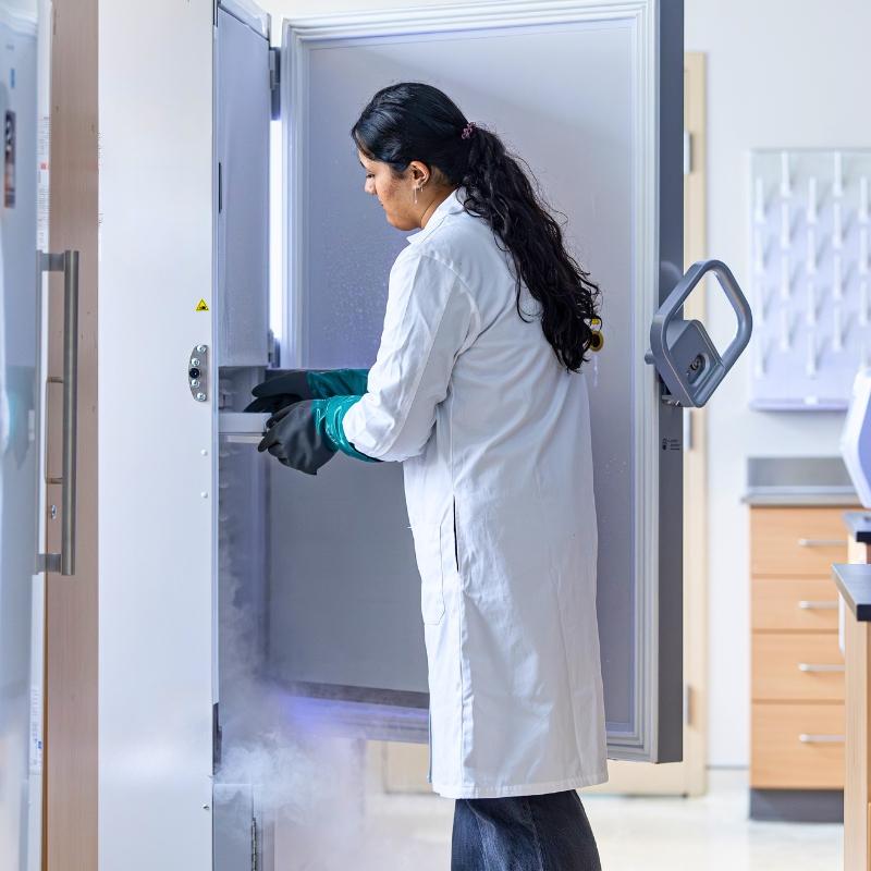Student carries a tray from a freezer