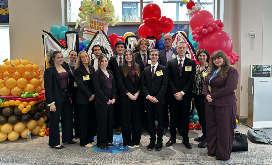 Group of students in black suits standing and smiling