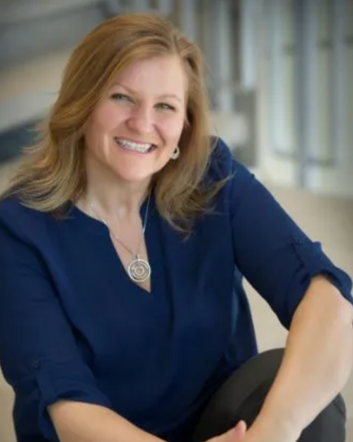 Crystal Mackay in a blue shirt smiling at the camera