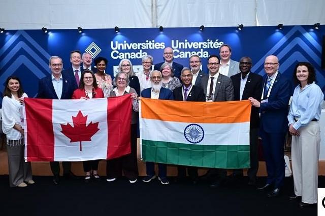 Canadian university presidents stand in front of Canadian and India Flags