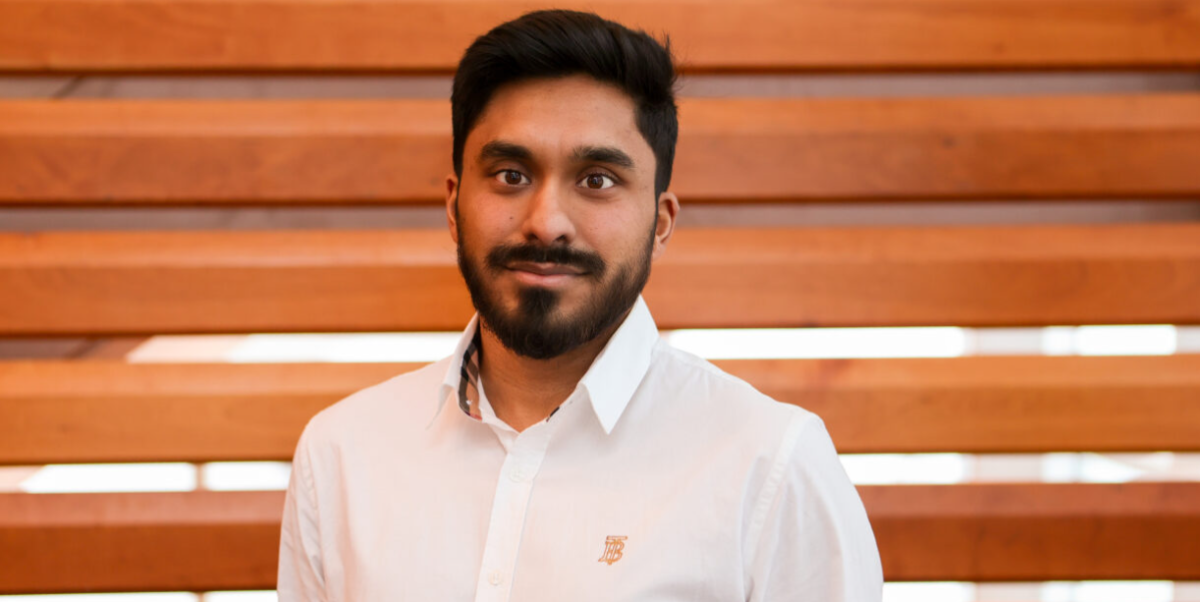 Dr Shadman Khan in a white dress shirt looking directly at the camera and smiling