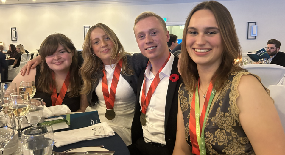Group of students wearing first place medals and smiling
