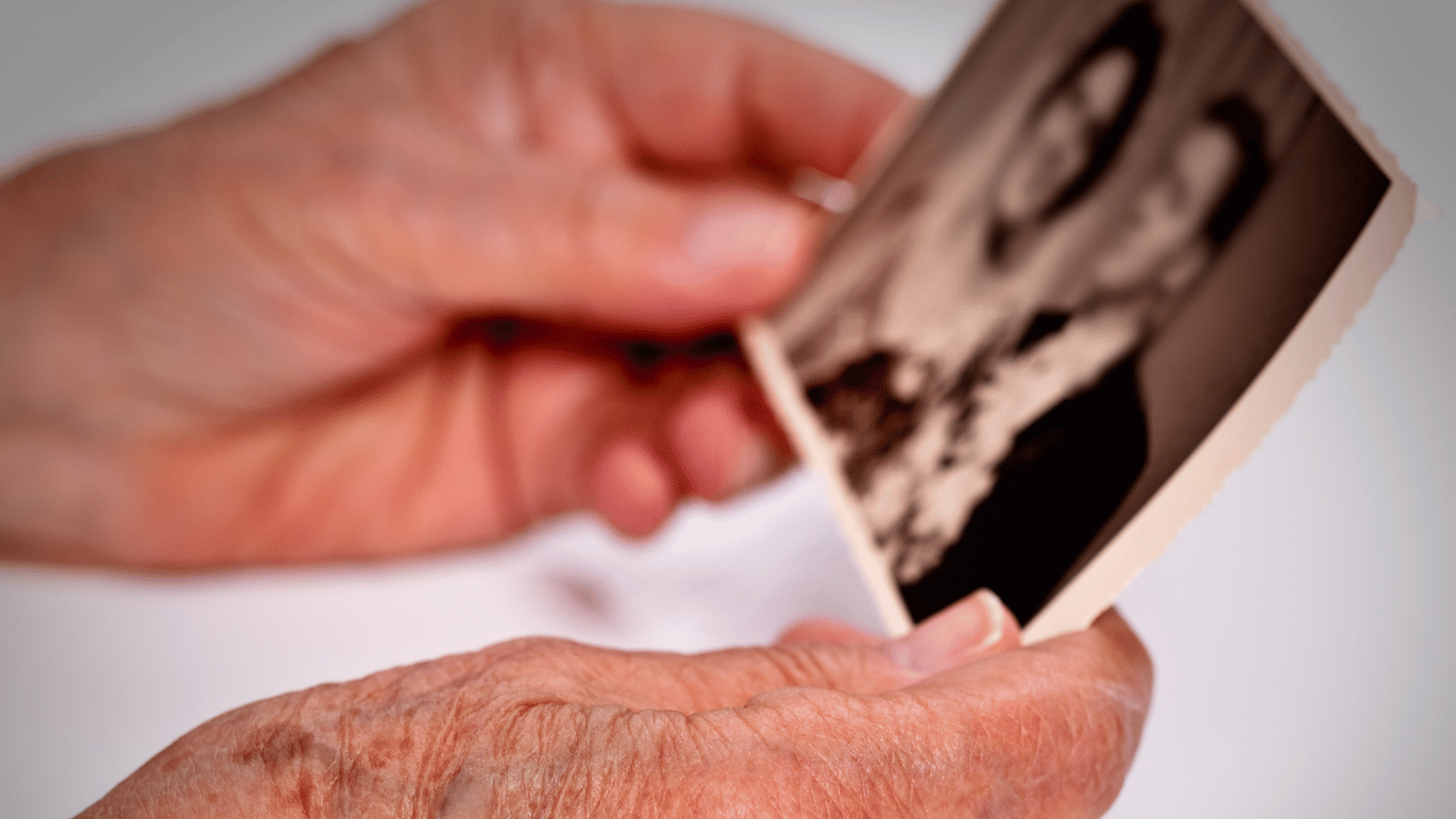 Hands holding a vintage black and white wedding photograph.