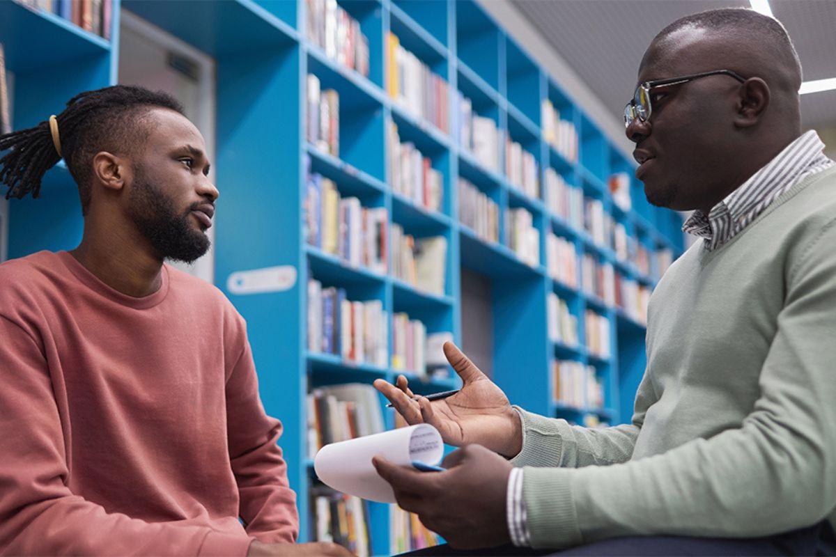 A counsellor sits a with student providing support