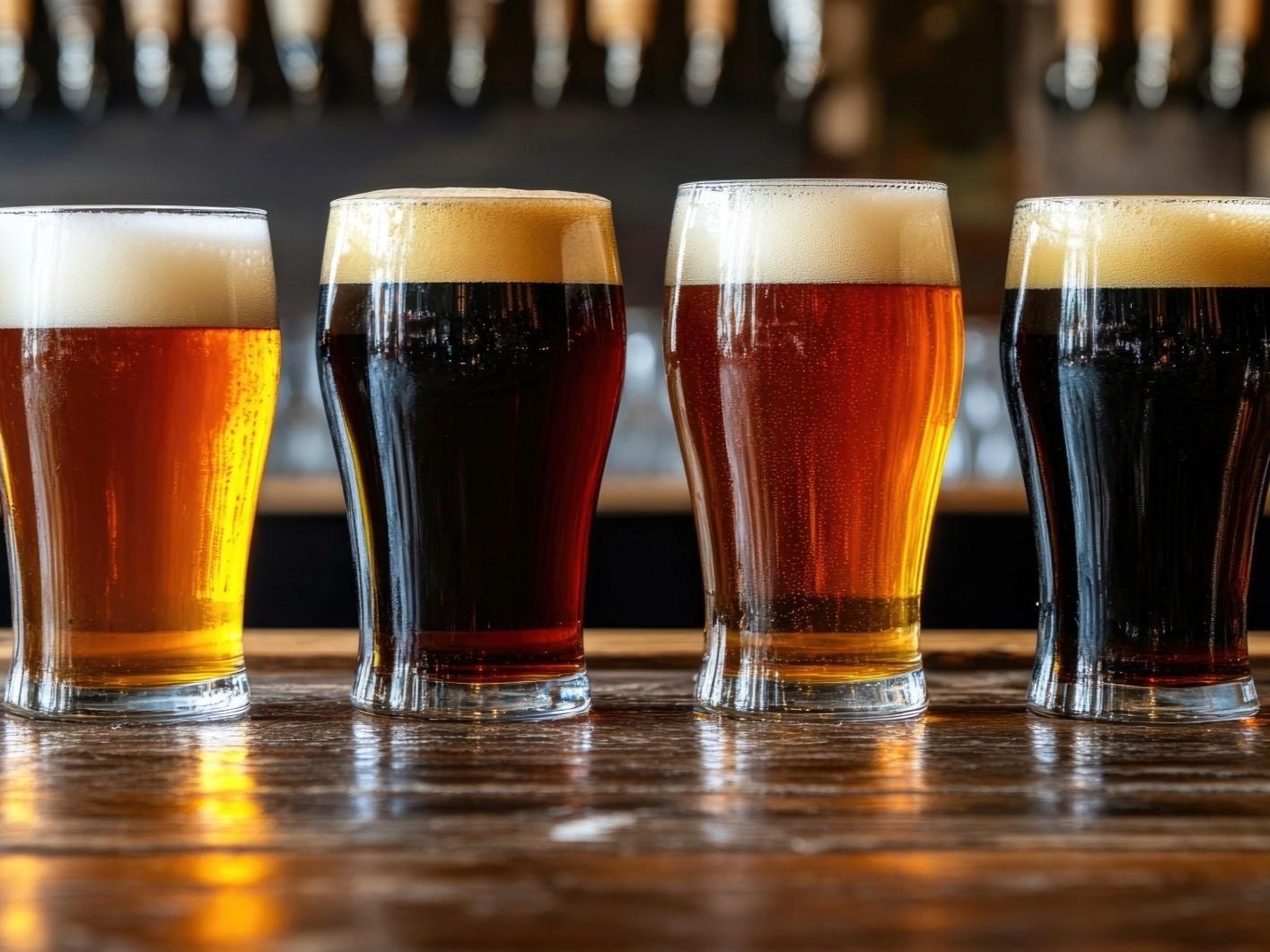 Four pint glasses with different types of beer in them