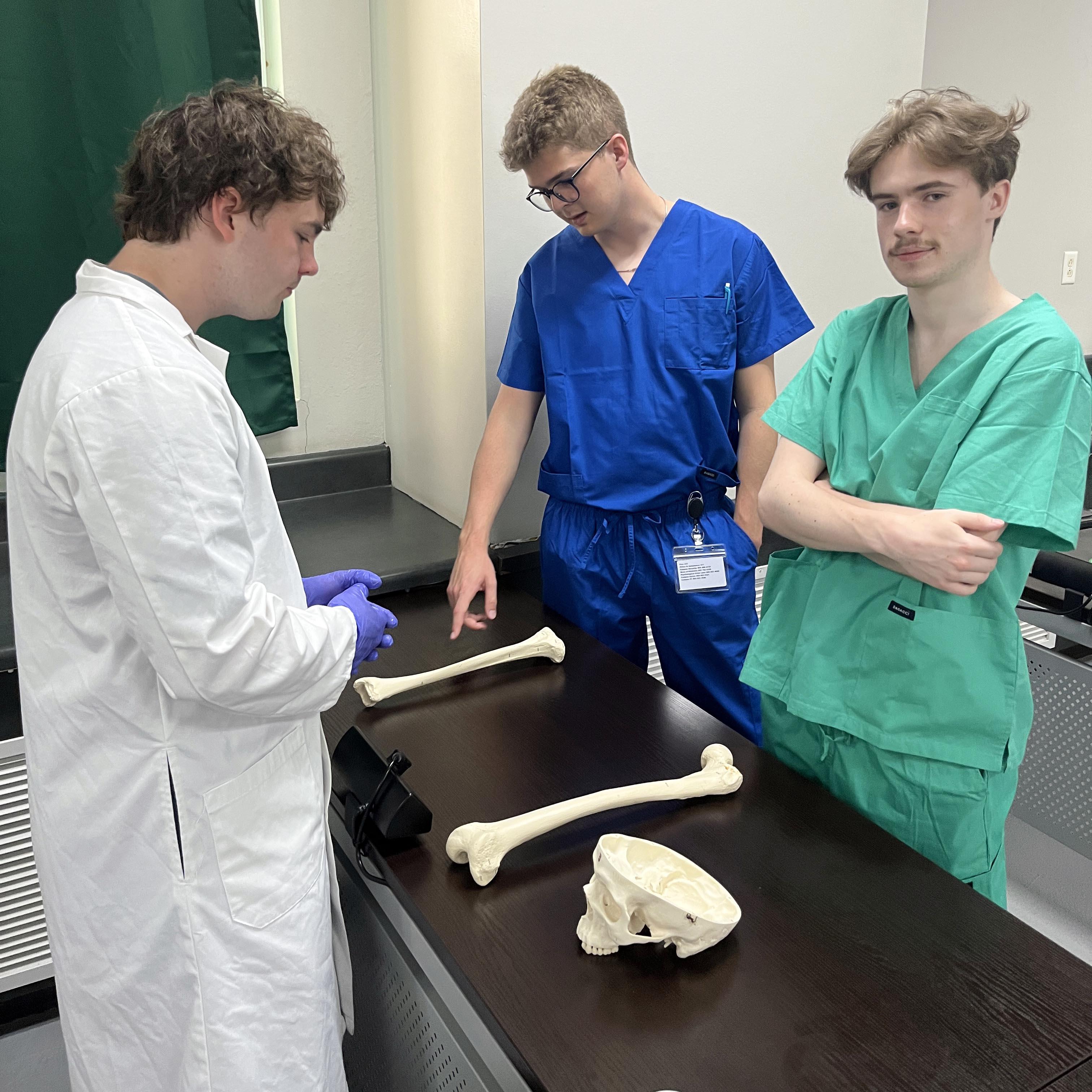 Students stand around a table with plastic bones