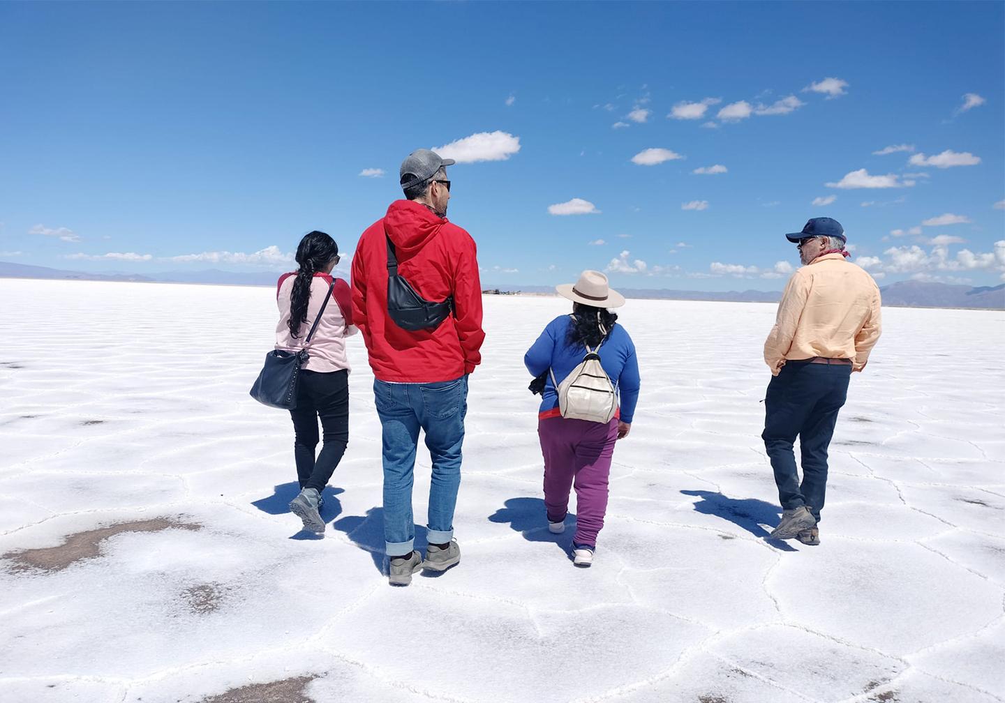 Four people walking across salt flats in Argentina