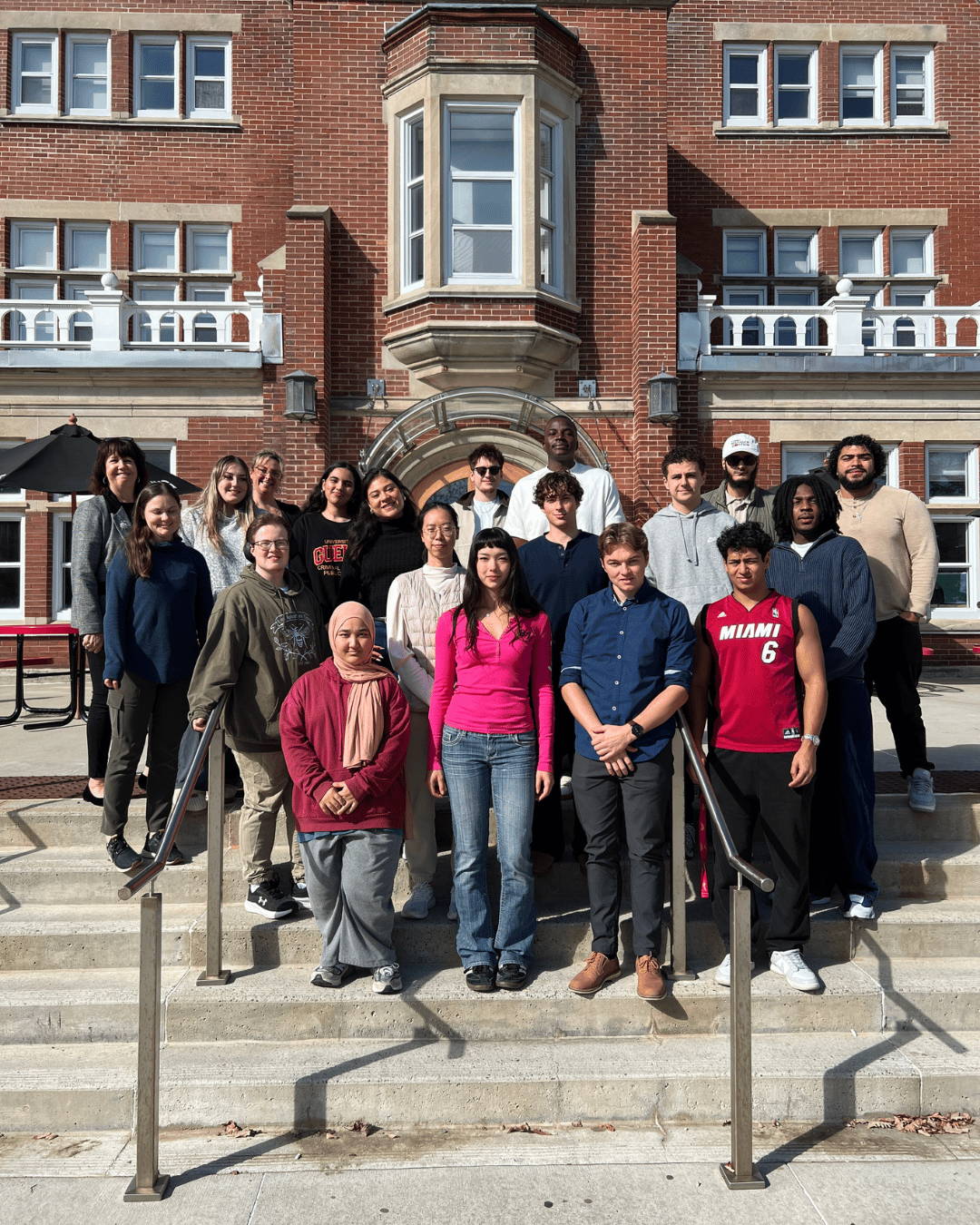 A group of students standing outside smiling at the Camera