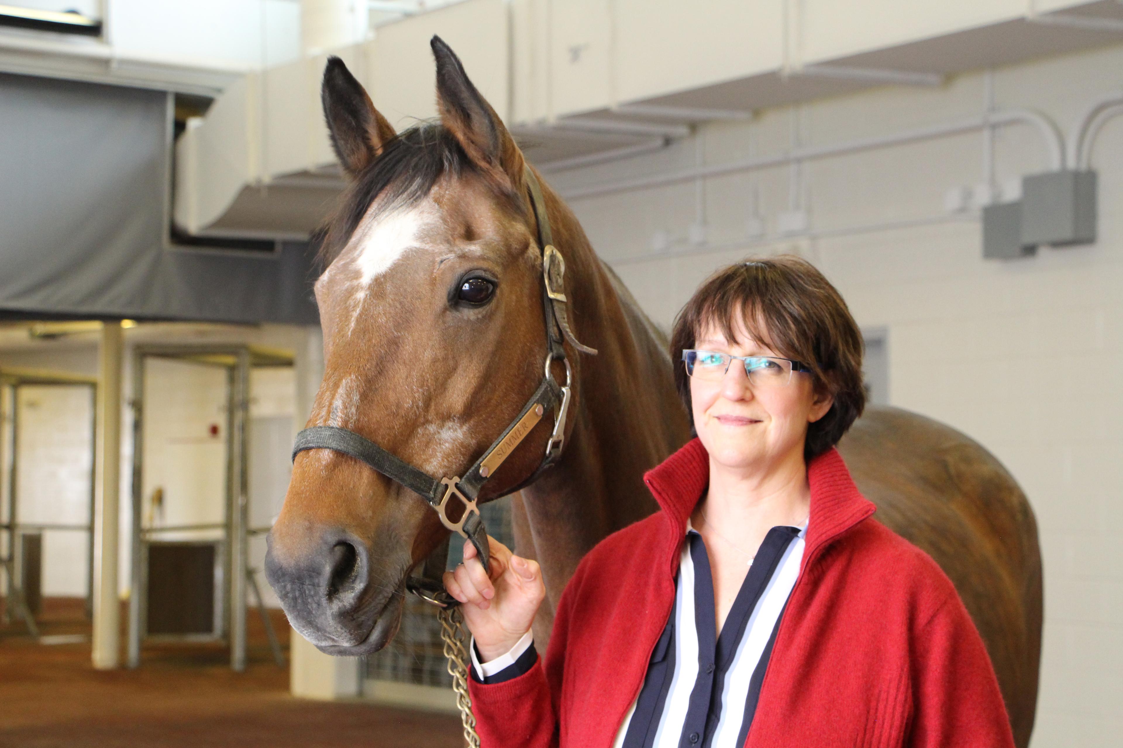 Photo of a woman with a horse next to her