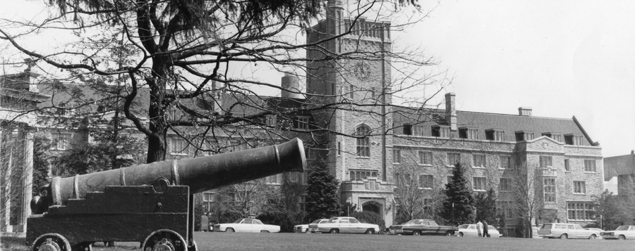 A historic photo of Johnston Hall with "Old Jeremiah" the cannon perched in front, on Johnston Green