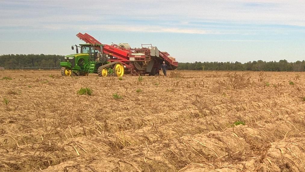 A tractor travels across a dirt field