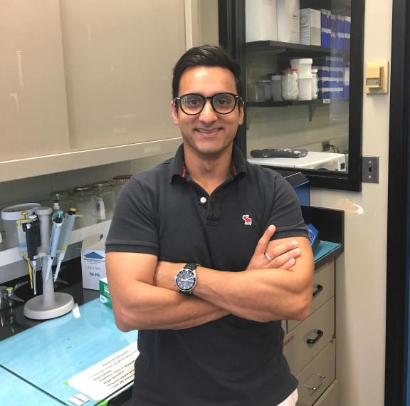 Photo of Sudan Sudhanshu standing with his arms crossed in front of a lab bench.