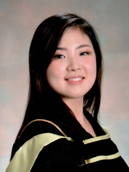 Headshot of April Xu wearing graduation robes against a grey backdrop.
