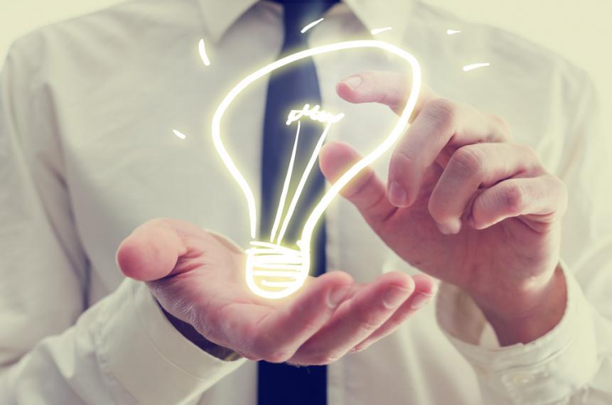 Abstract image of a neon light bulb resting on someones hand