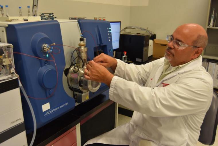 Man connecting wires on lab equipment