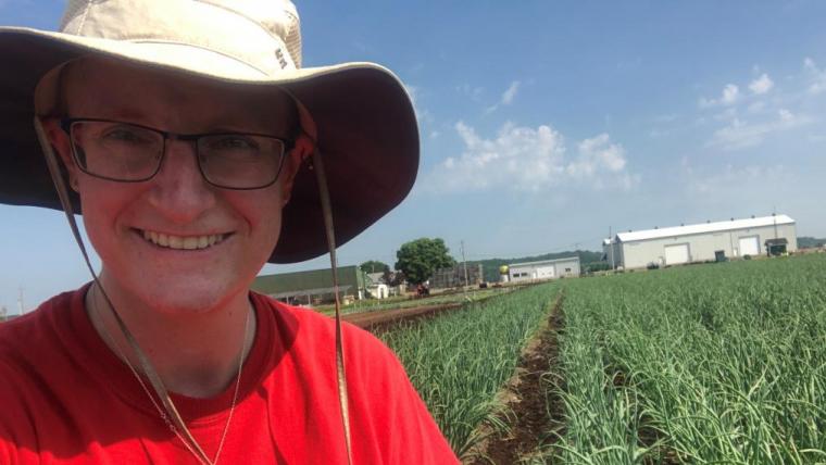 Sara Stricker in the field with the onions