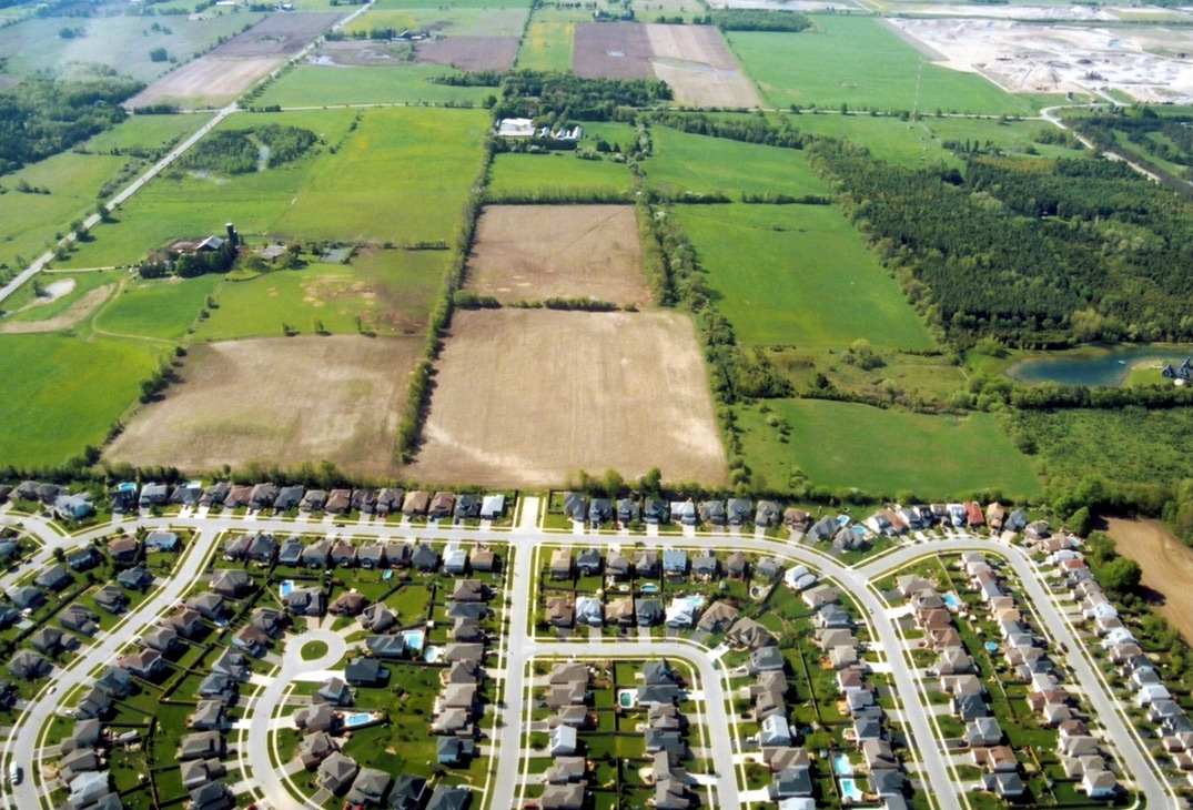 An aerial view of an urban area abutting farmland
