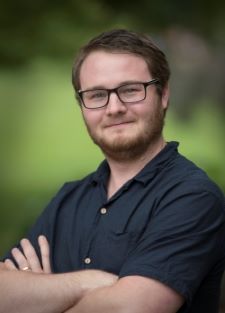 Dr. David Huyben, a confident researcher wearing glasses