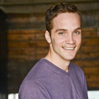 a picture of robert allan wearing a purple t-shirt