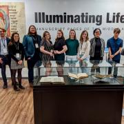 Student curators pose in front of gallery wall