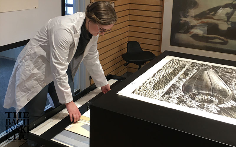 Students examining fine art prints in the collection