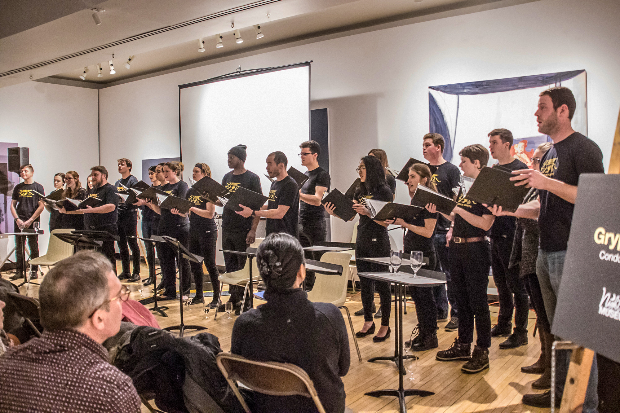 Marta McCarthy, Gryphon Singers conductor, smiles on towards the audience during their performance.