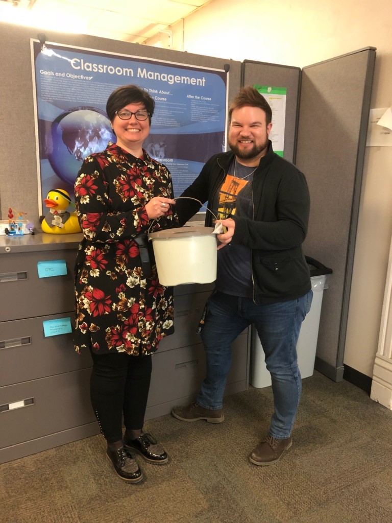 two Day Hall staff pose with an office compost bin