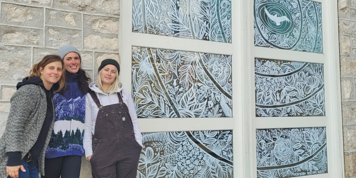 Organizers in front of a mural at Guelph City Hall