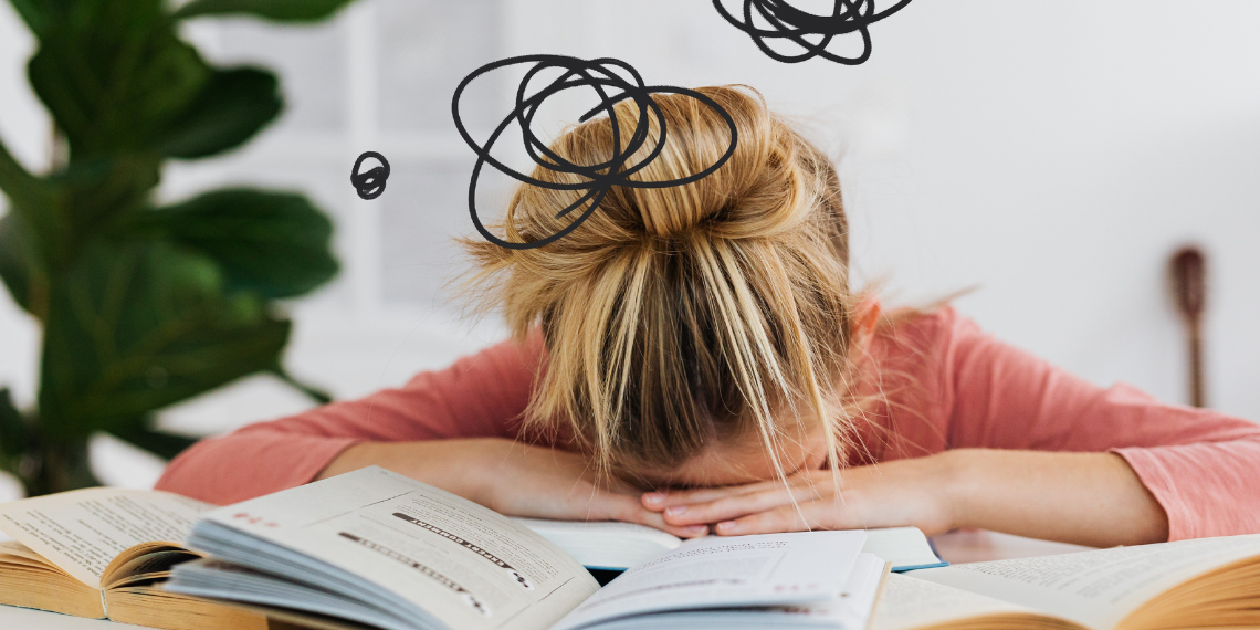 Woman looking stressed and frustrated behind an open book
