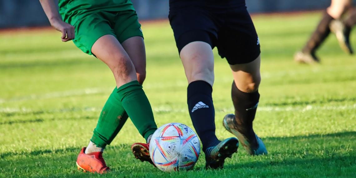 Soccer players kicking a ball