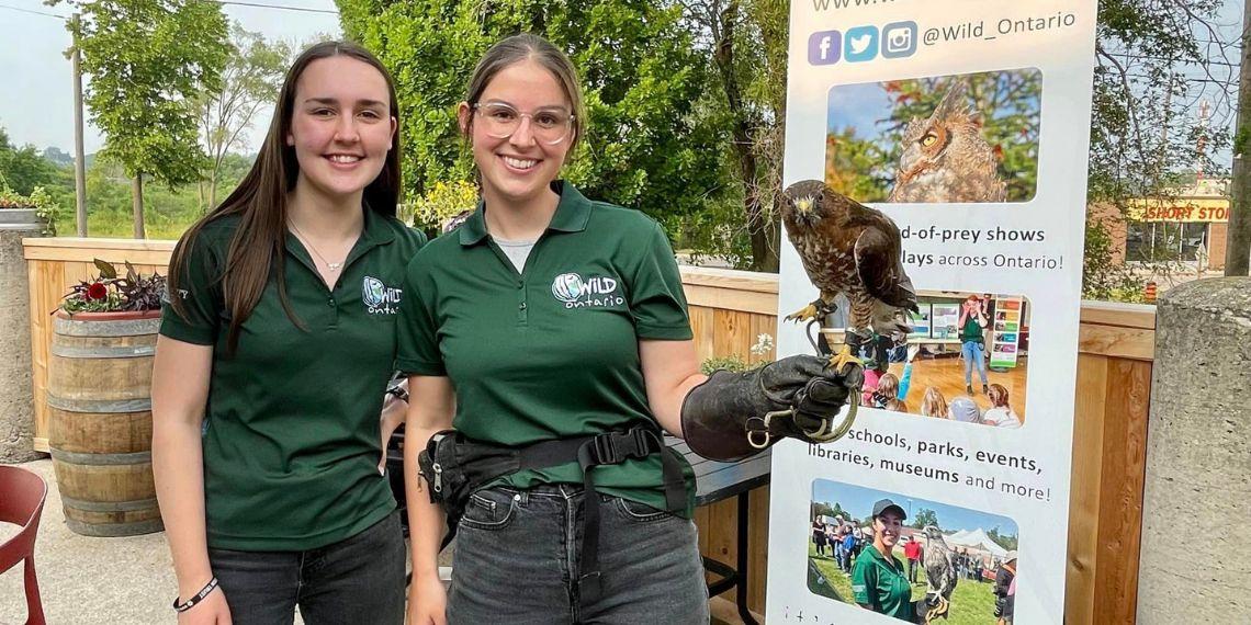 Wild Ontario volunteers pose with red-tailed hawk at Community Collab launch party