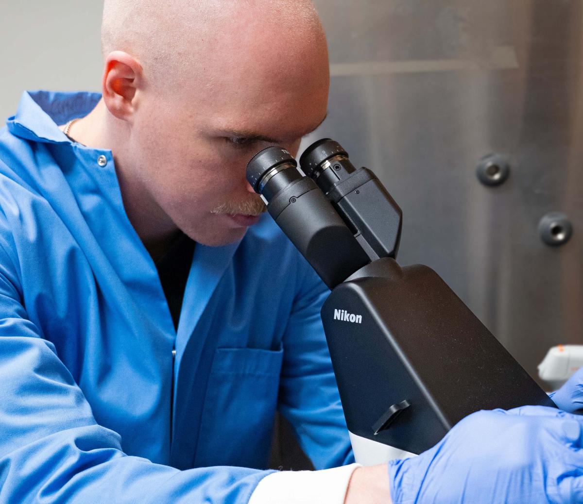 Colin Guth looks through a microscope