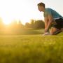 male running on a grassy field