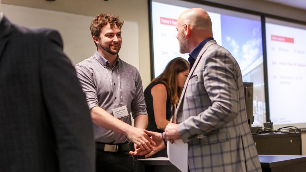Jacob Drobena shaking hands with someone.