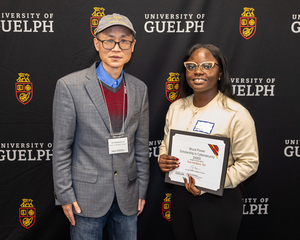 Dr. Xiaodong Lin and Yaa Kusi-Fordjour standing together with an award.
