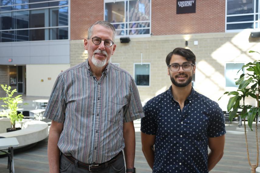 Headshot of Dr. Adrian Schwan and PhD student Adam Riddell standing side by side.