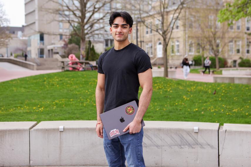 Pareesh Madan holding a laptop and smiling.