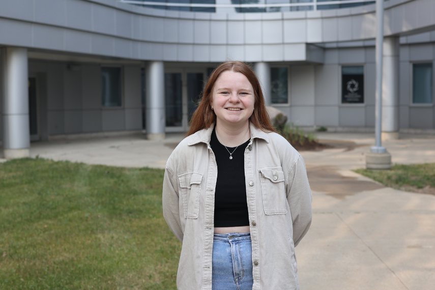 Female student standing outside in front of building