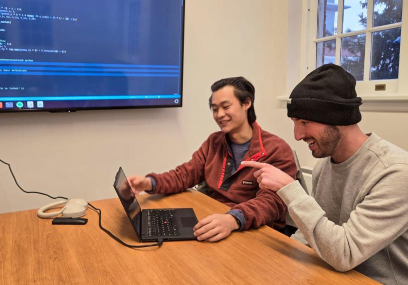 Two students working on a computer together.