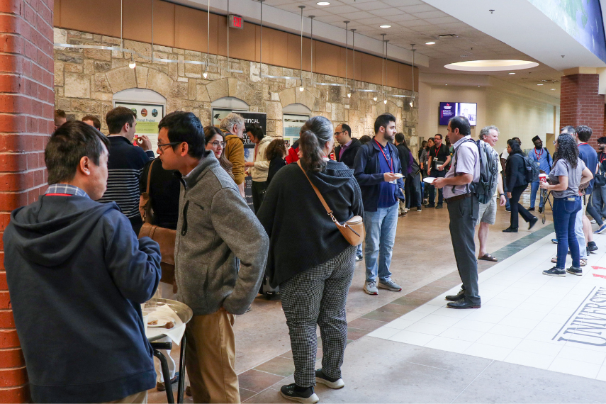 Attendees in Rozanski Hall, talking amongst themselves.