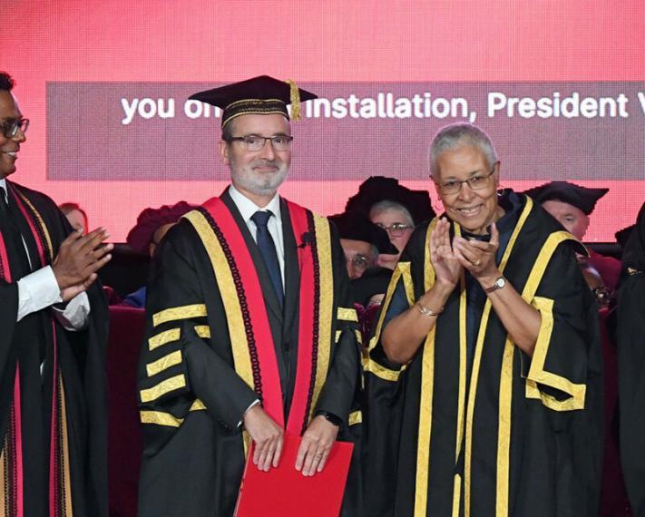 Dr. Rene Van Acker standing on convocation stage.