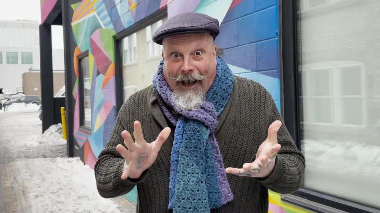 Orbax standing outside holding his hands up.