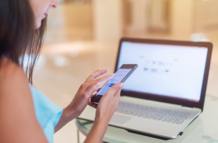 Person on their phone with computer in background