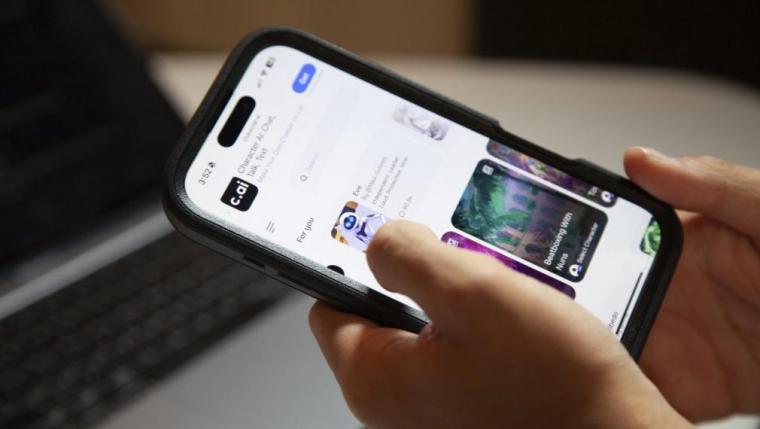 Hands holding a mobile phone with a lit up screen.