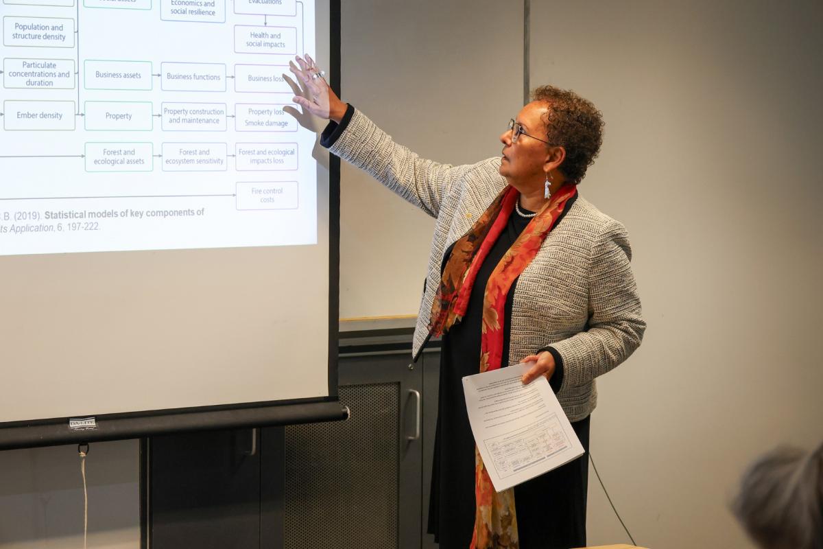 Dr.Dean pointing to a slideshow while leading a lecture.
