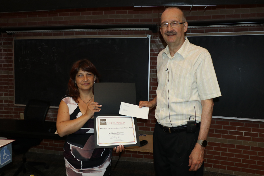 Man and woman holding an award.