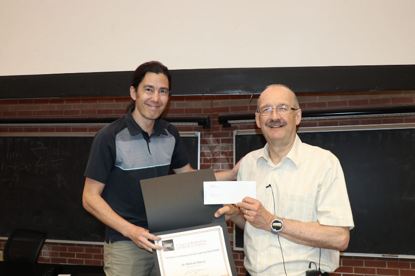 Two men holding an award.